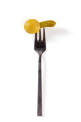 Olive with a mini gherkin on a fork, top shot on a wine background