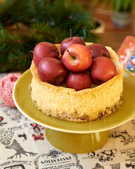 Sponge cake with apples on a green plate on the table. Homemade pie