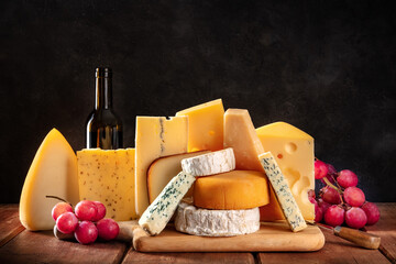 Cheese, fruit, and wine. A selection of various cheeses, side view