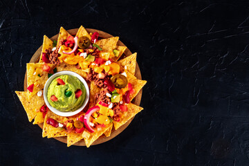 Mexican nacho chips with meat and guacamole