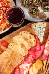 Italian antipasti with wine, shot from above. Bread, cheese, ham, artichokes