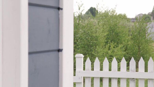 beautiful white wooden fence and green grass on lawn. Blue sky.