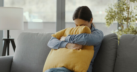 Depressed woman sitting on the sofa at home