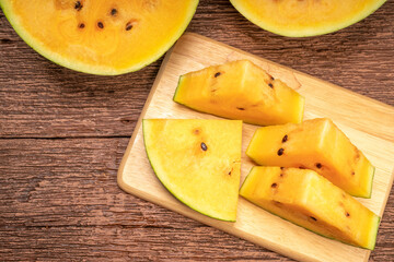 Yellow watermelon on the wooden background.