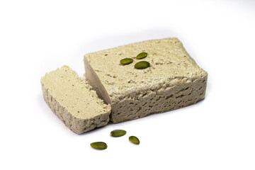 Halva close-up. Halva briquette isolated on white background. Sweet oriental dessert halva with pumpkin seeds. Sweets for tea.