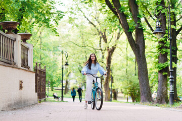 Fototapeta na wymiar Young woman riding retro bike during warm day outdoors