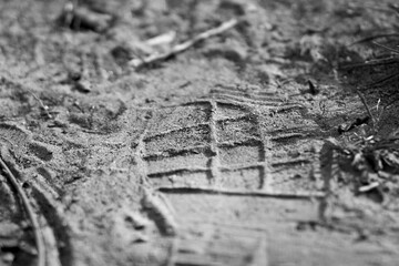 A footprint in the sand from a shoe or boot	