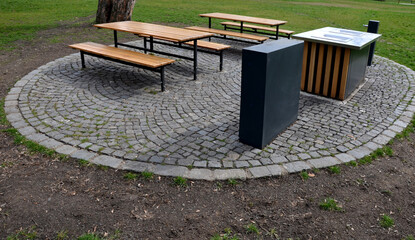 Park seating with wooden tables and benches for picnic and barbecue with gas grills. The kitchen...