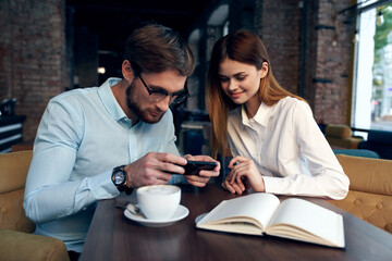 business man and woman sitting at the table communication work colleagues technology