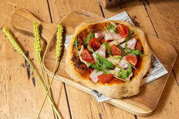 Pizza de tomate con beicon y rúcula
