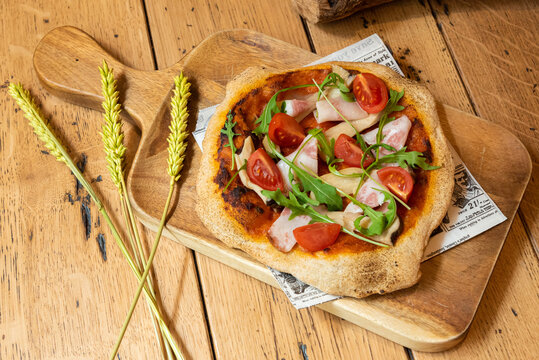 Pizza de tomate con beicon y r&uacute;cula
