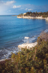 Beautiful small white bench on the Governor's beach near Limassol, Cyprus.