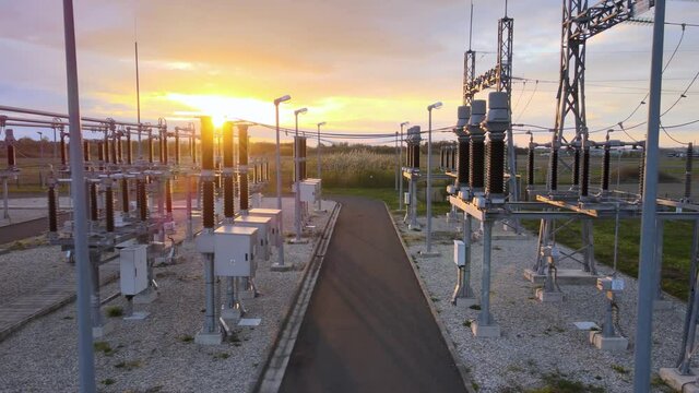 Electrical power station, with colorful sunset sky background - Tracking view