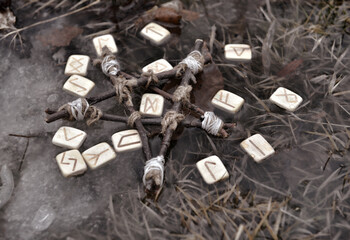 Still life with pentagram and wooden runes in the water outside.  Esoteric, gothic and occult...
