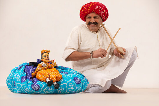 A HAPPY RURAL ARTIST PLAYING EKTARA FOR TRADITIONAL PUPPET SHOW	