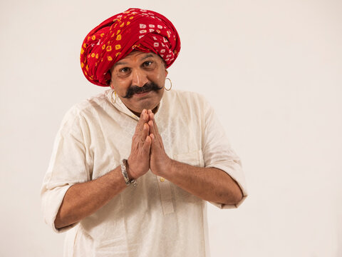 A TURBANED ADULT VILLAGER GREETING WITH FOLDED HANDS - Powered by Adobe