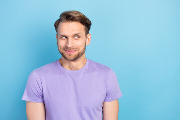 Obraz premium Portrait of funky optimistic blond hair guy look empty space wear purple t-shirt isolated on light blue color background