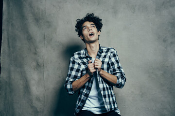 Cheerful guy curly hair and plaid shirt modern style studio model