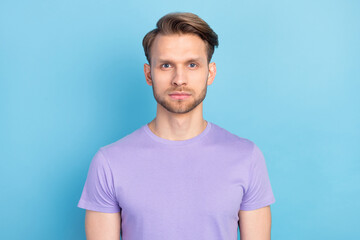 Photo of handsome serious blond hair guy wear purple t-shirt isolated on light blue color background