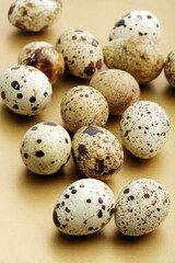 Lots of quail eggs on a beige background.