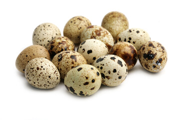 Many quail eggs are isolated on a white background.