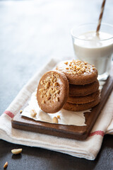 a stack of shortbread homemade cookies with peanuts on a wooden background with milk. peanut cookie