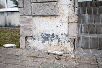 Facade of a public building. Stone finishing tiles. Aging, poor quality and refurbishmen