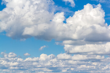 Naklejka na ściany i meble Blue sky with white fluffy clouds background.