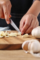 Obraz na płótnie Canvas Chef chopped garlic on wooden cutting board