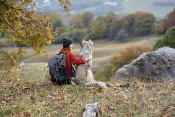 woman hiker with dog in nature admire the mountains travel