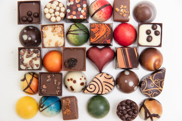 lot of variety chocolate pralines, top view of various chocolate pralines isolated on white background
