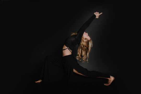 Frau macht Yoga entspannt, kraftvoll, Balance, &Uuml;ben, Fitness, dunkler Hintergrund, Lunge Pose, Ashva Sanchalanasana