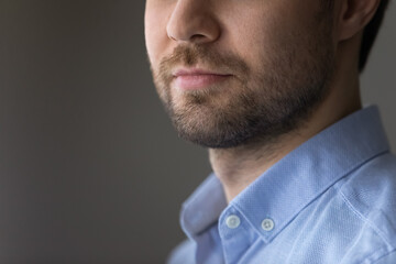 Fototapeta premium Crop close up of young Caucasian man isolated on gray background look in distance thinking pondering of new opportunities. Determined male make plan decision, motivated for success. Vision concept.