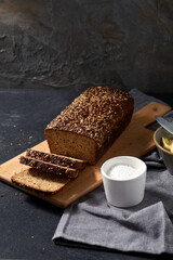 food, baking and cooking concept - close up of bread, butter in bowl, table knife and salt in cup on towel