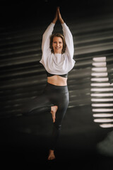 Frau macht Yoga entspannt, kraftvoll, Balance, Üben, Fitness, dunkler Hintergrund, Lichteinfall,...