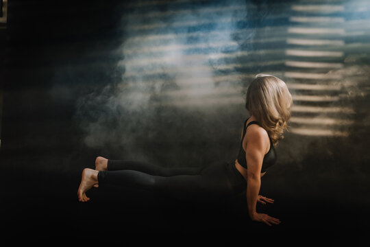 Frau macht Yoga entspannt, kraftvoll, Balance, &Uuml;ben, Fitness, dunkler Hintergrund, Lichteinfall, Nebel, Nach oben schauender Hund, Upward facing dog, Adho Mukha Svanasana