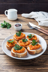 Sandwiches with bread zucchini caviar tomatoes onions. Homemade vegetarian food. Canned stewed vegetable. wooden background