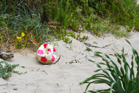 Foto concettuale di inciviltà, pallone da calcio scoppio, abbandonato in una spiaggia