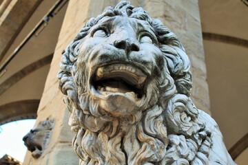 Florence, Tuscany, Italy: ancient statue of a lion in Piazza della Signoria, sculpture that depicts a lion with a sphere under one paw