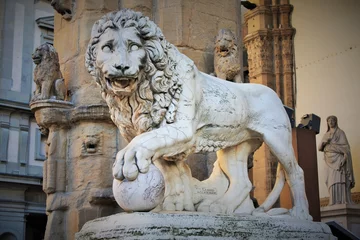 Fotobehang Florence, Tuscany, Italy: ancient statue of a lion in Piazza della Signoria, sculpture that depicts a lion with a sphere under one paw © Miroslav110