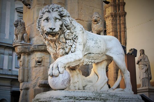 Florence, Tuscany, Italy: ancient statue of a lion in Piazza della Signoria, sculpture that depicts a lion with a sphere under one paw