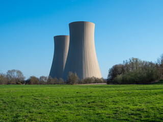 nuclear power plant against sky and green grass