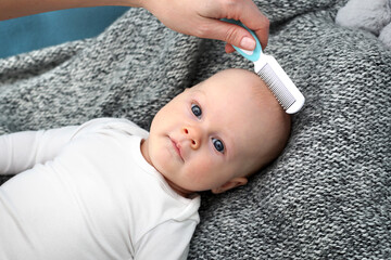 Baby care.
A young parent is brushing his baby.