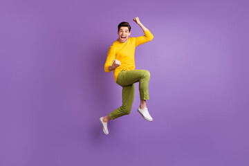 Full size photo of young happy excited crazy positive smiling man jumping in success victory isolated on violet color background