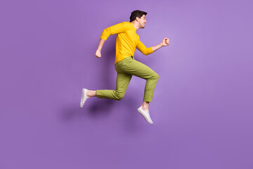 Fototapeta na wymiar Full length profile side photo of young man happy positive smile jump go walk run hurry sale isolated over violet color background