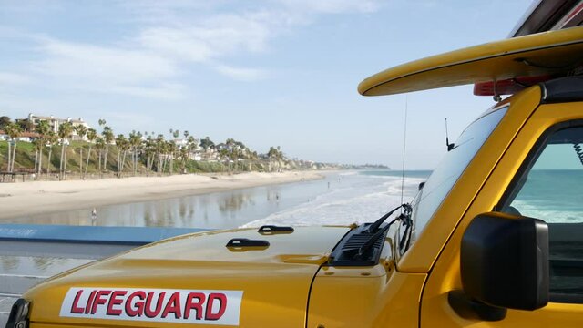 Yellow lifeguard car, San Clemente beach pier, California USA. Coastline rescue life guard pick up truck, lifesavers vehicle. Auto and ocean coast. Los Angeles vibes, summertime aesthetic atmosphere.