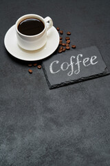 Coffee handwritten inscription sign on chalk board and cup of espresso coffee