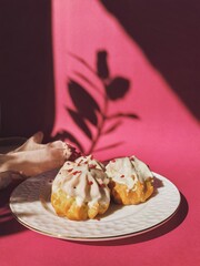 Delicious eclairs on a plate decorated with dried raspberries. Concept baking, cookbook recipes, bakery banner, cafe advertisement.