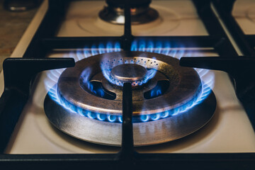 Burning blue gas. Focus on the front edge of the gas burners. Flame burning from a kitchen gas...