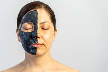 Woman relaxing with black charcoal facial mask